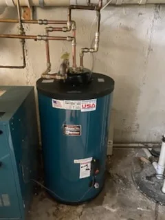 Indirect-fired water heater installed beside a boiler in a basement