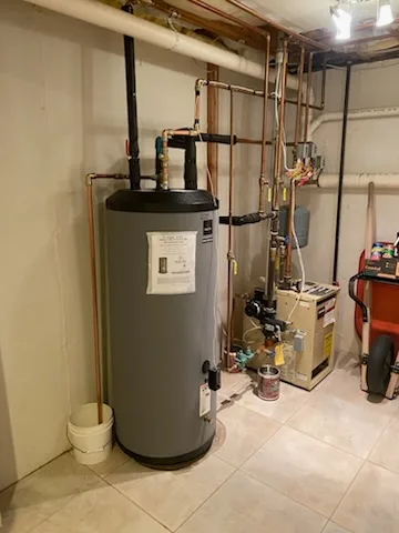 Indirect hot water tank with new copper piping beside a boiler